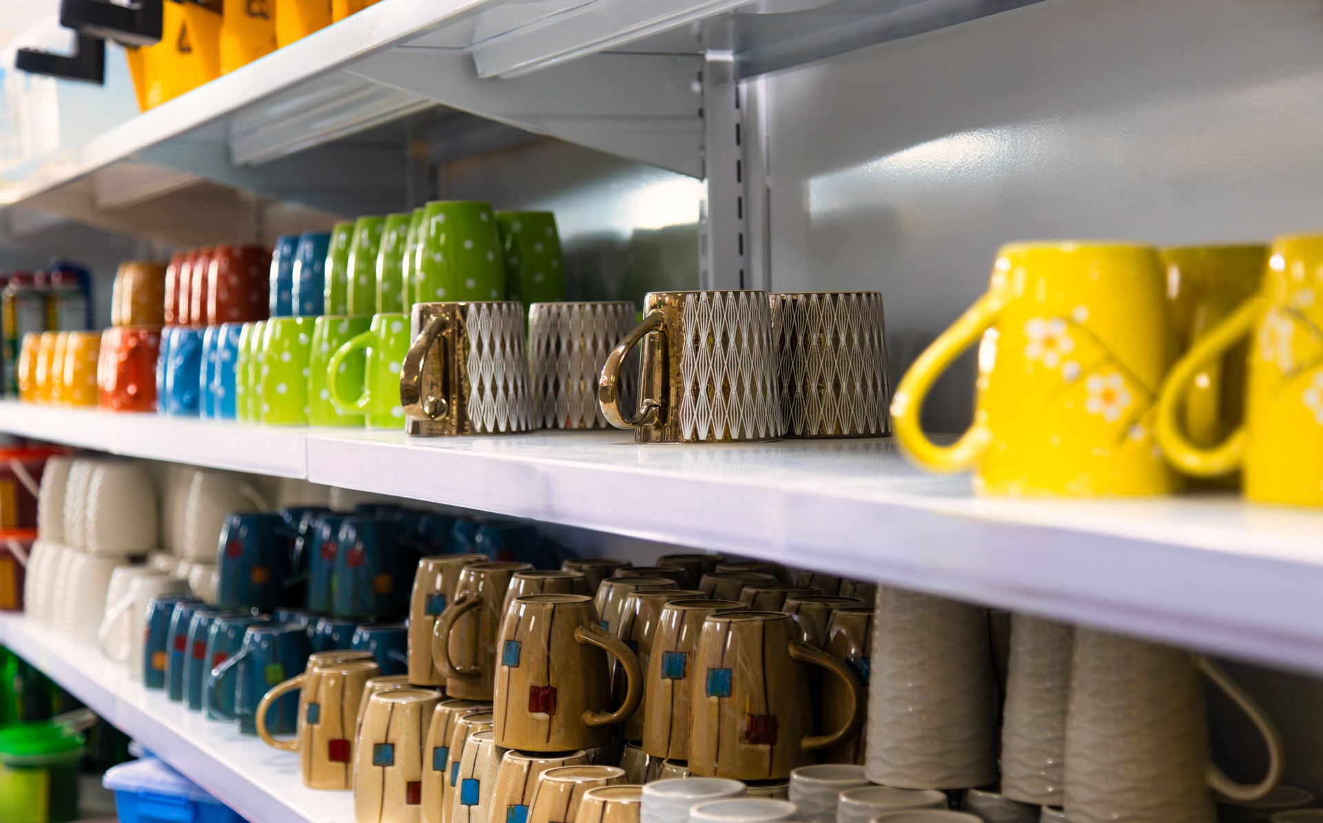 shelves with colorful coffee mugs in a shop for sale